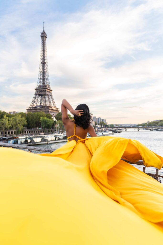 Séance photo de Flying Dress à Paris devant la tour Eiffel avec une robe jaune.